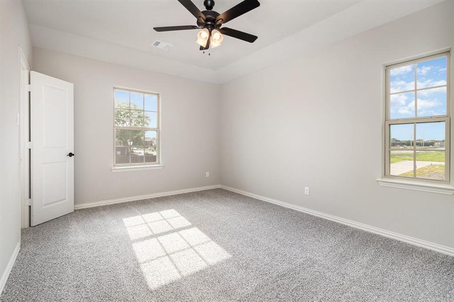 Empty room with carpet floors and ceiling fan