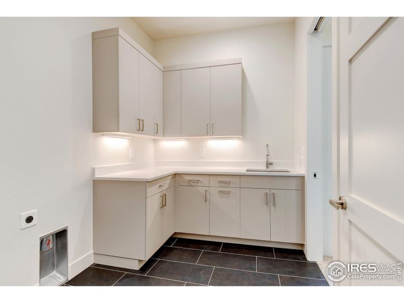 Laundry room with access to primary closet