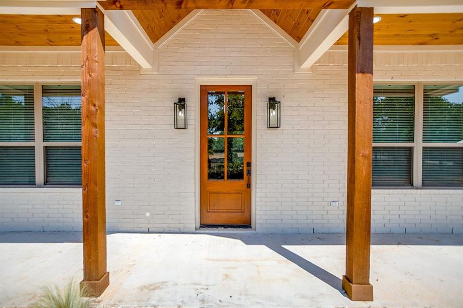 Property entrance with a porch and brick siding Property entrance with a porch and brick siding