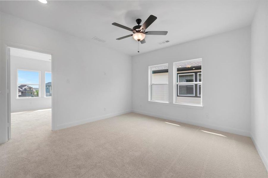 Empty room featuring light carpet and a ceiling fan