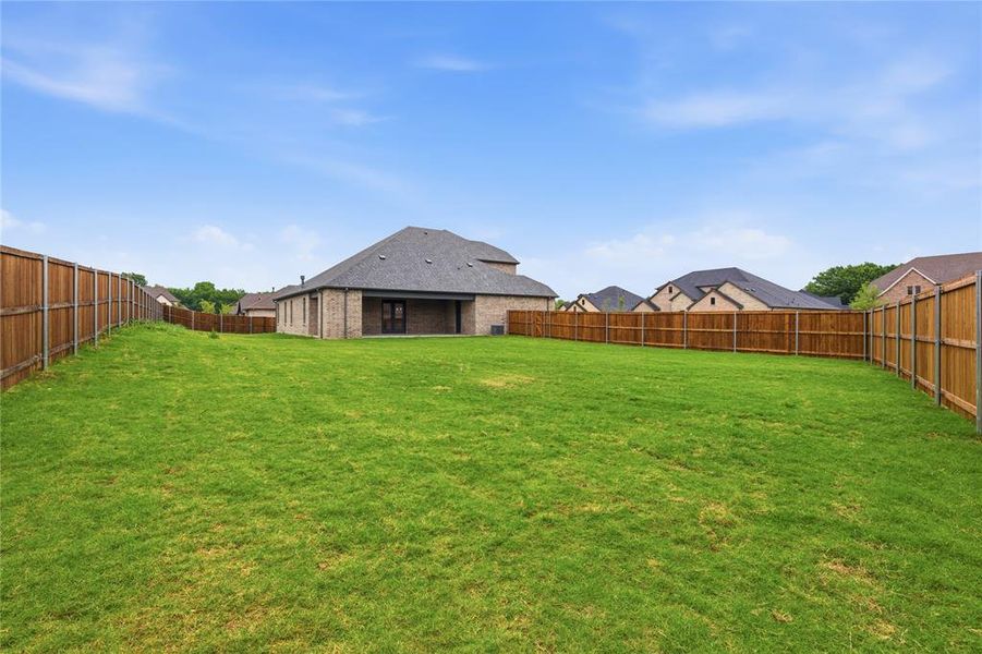 Expansive green lawn with a full wood privacy fence Expansive green lawn with a full wood privacy fence