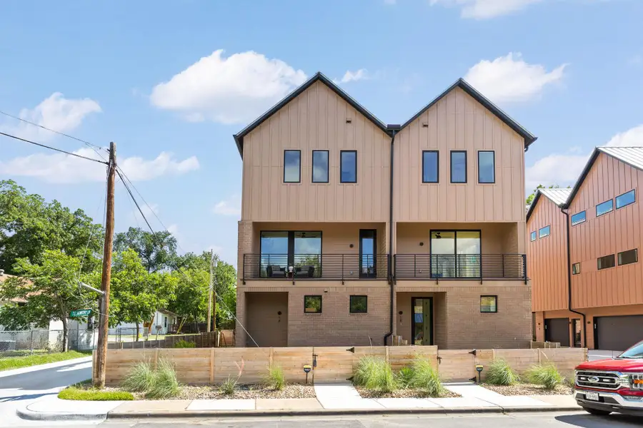 Modern dual-gabled architecture merges board-and-batten siding with a brick lower level. Modern dual-gabled architecture merges board-and-batten siding with a brick lower level.