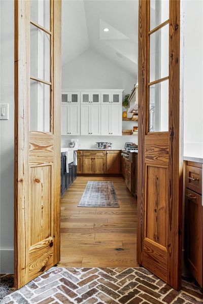 Kitchen with white cabinetry and lofted ceiling