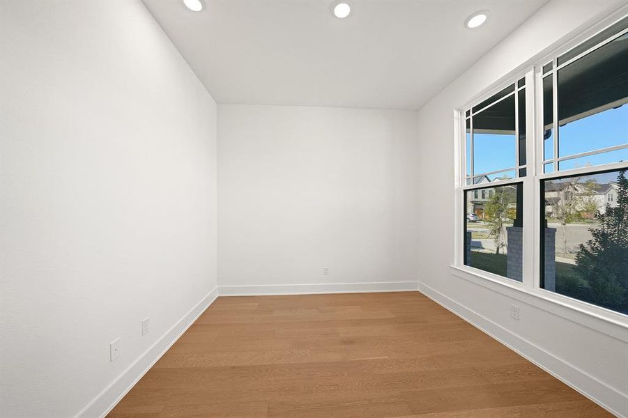 Empty room with light wood finished floors and recessed lighting Empty room with light wood finished floors and recessed lighting