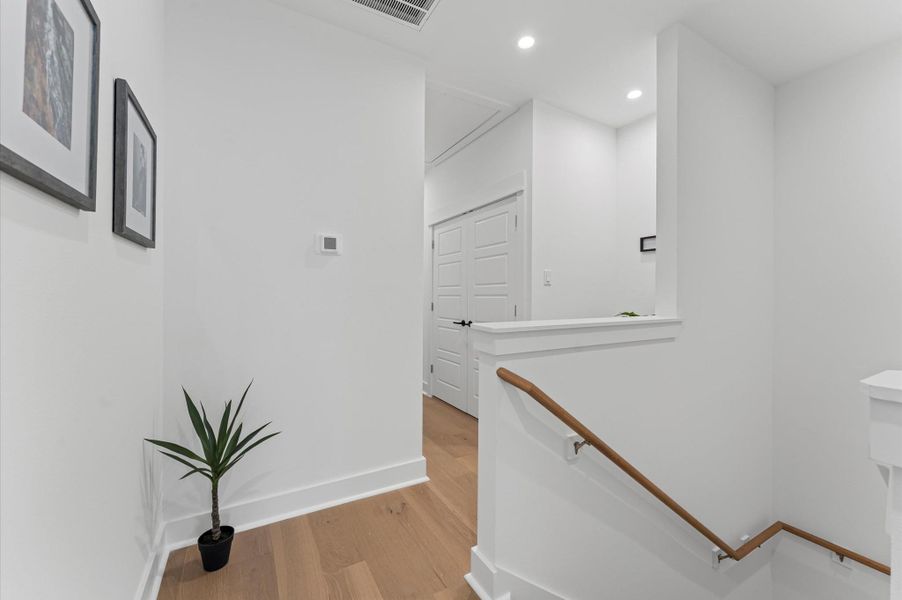 At the top of the staircase, this thoughtfully designed second-floor hallway serves as both a connector and a subtle divider between the primary suite and the secondary bedrooms. With its clean lines and open layout, the space offers a sense of flow while preserving privacy.