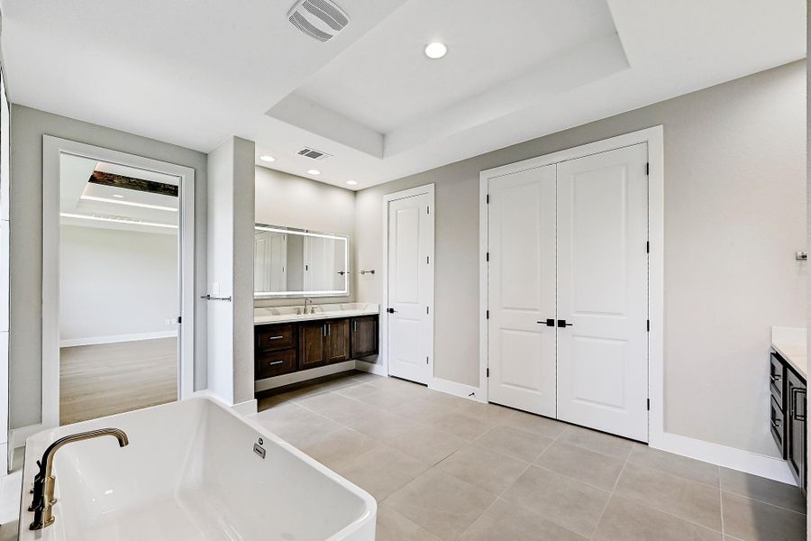 Indulge in a tranquil retreat featuring a spacious soaking tub and dual vanities, offering abundant space and style.