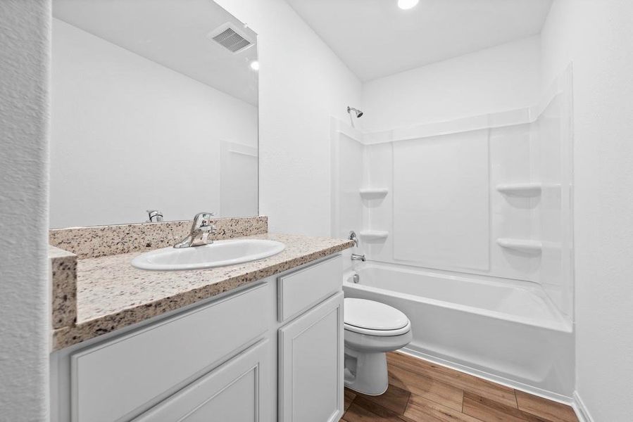 Secondary bathroom includes granite counters, designer white cabinetry and luxury vinyl plank flooring. Secondary bathroom includes granite counters, designer white cabinetry and luxury vinyl plank flooring.