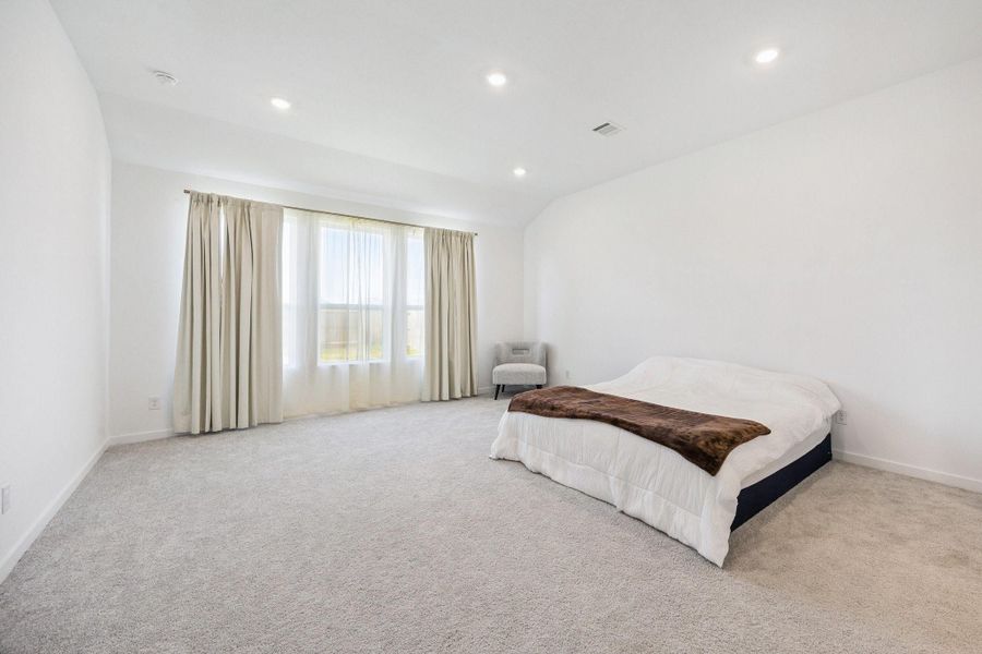 This spacious primary bedroom with recessed lightning has plenty of room to easily fit large furniture pieces. This spacious primary bedroom with recessed lightning has plenty of room to easily fit large furniture pieces.