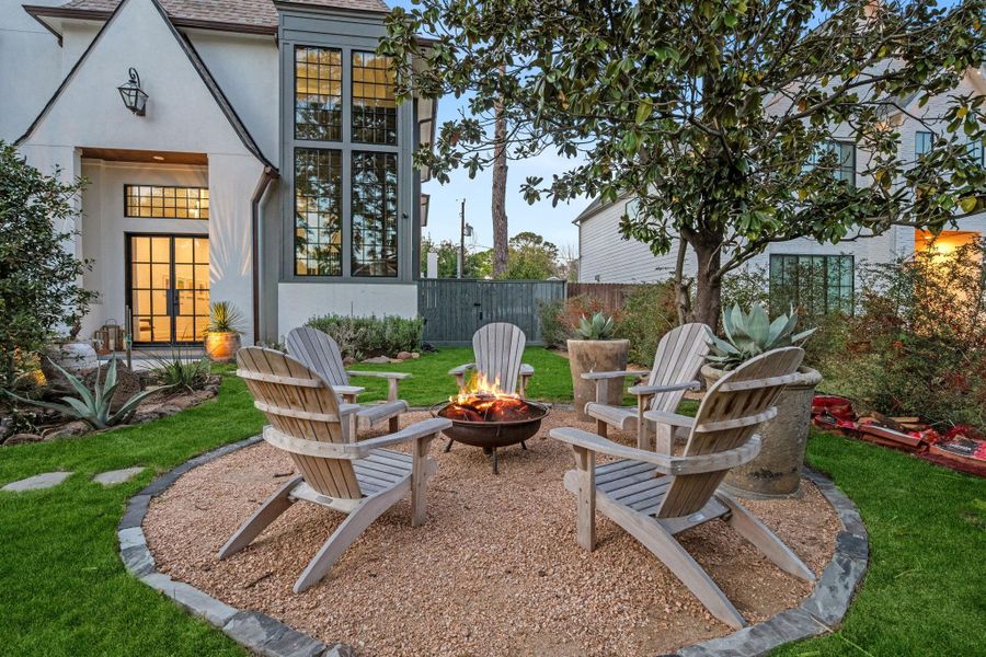 Front courtyard featuring a fire pit seating area surrounded by beautiful landscaping—an inviting outdoor space perfect for relaxing or gathering.