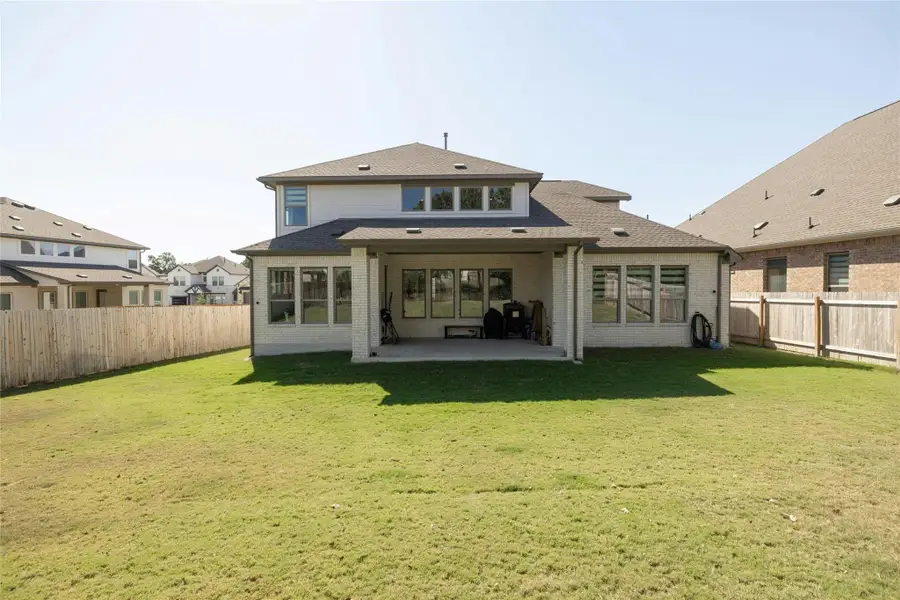 Rear view of property with a patio, a fenced backyard, brick siding, and roof with shingles Rear view of property with a patio, a fenced backyard, brick siding, and roof with shingles