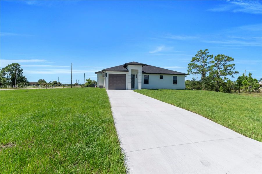 Front exterior of a new home in , Lehigh Acres, FL, highlighting curb appeal (Image 17).