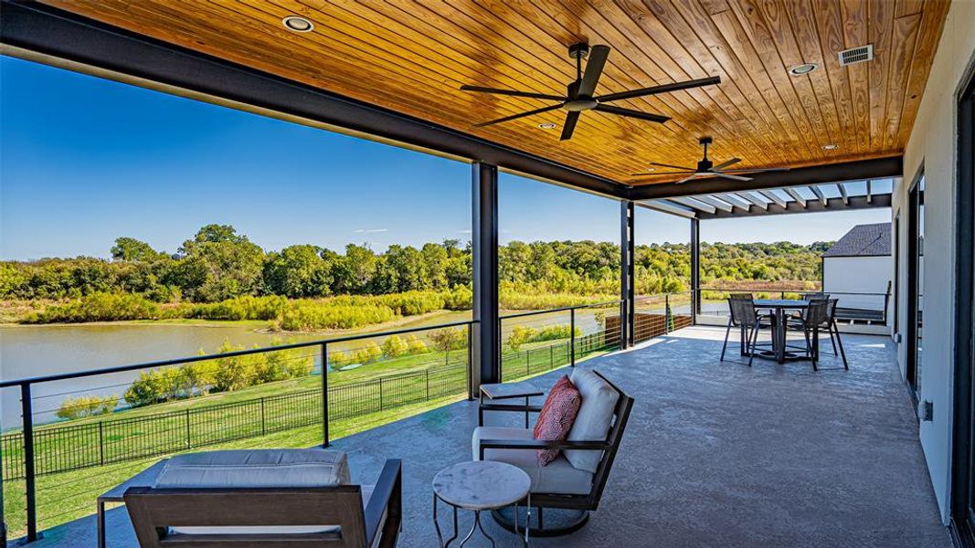 View of patio with a water view and a balcony