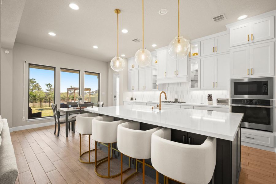 Kitchen featuring white cabinets, stainless steel appliances, recessed lighting, a kitchen bar, and tasteful backsplash Kitchen featuring white cabinets, stainless steel appliances, recessed lighting, a kitchen bar, and tasteful backsplash