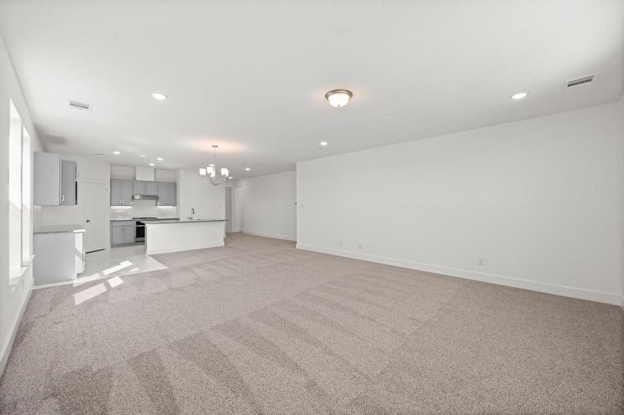 Living area with carpet flooring and lots of natural light