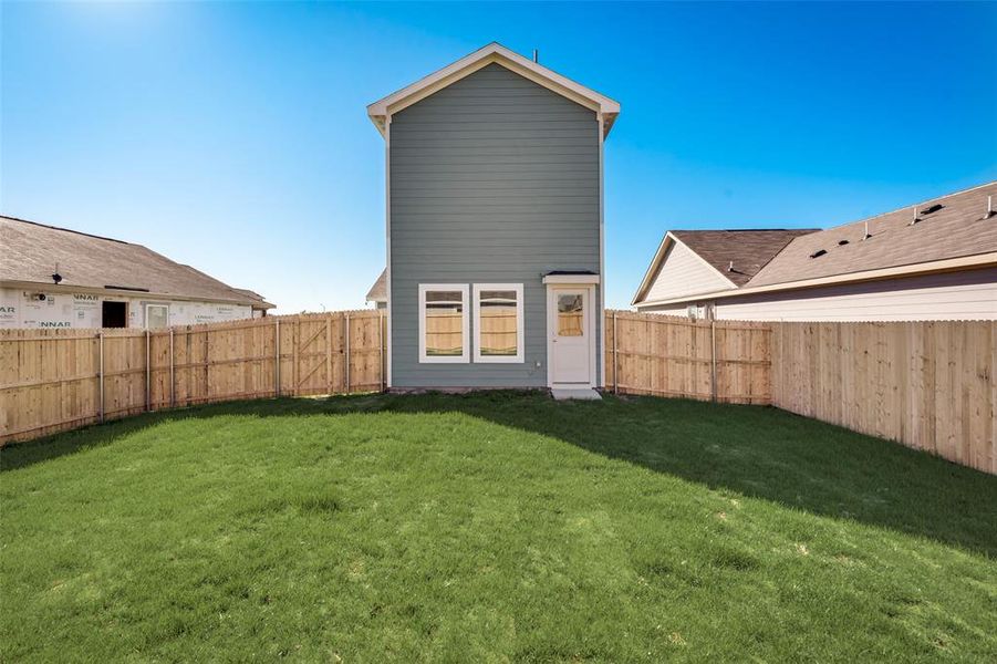 Rear view of house featuring a lawn