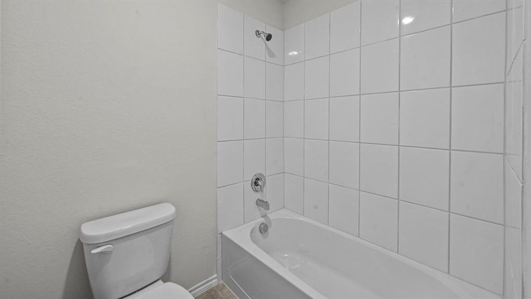 Full bathroom featuring toilet and shower / washtub combination