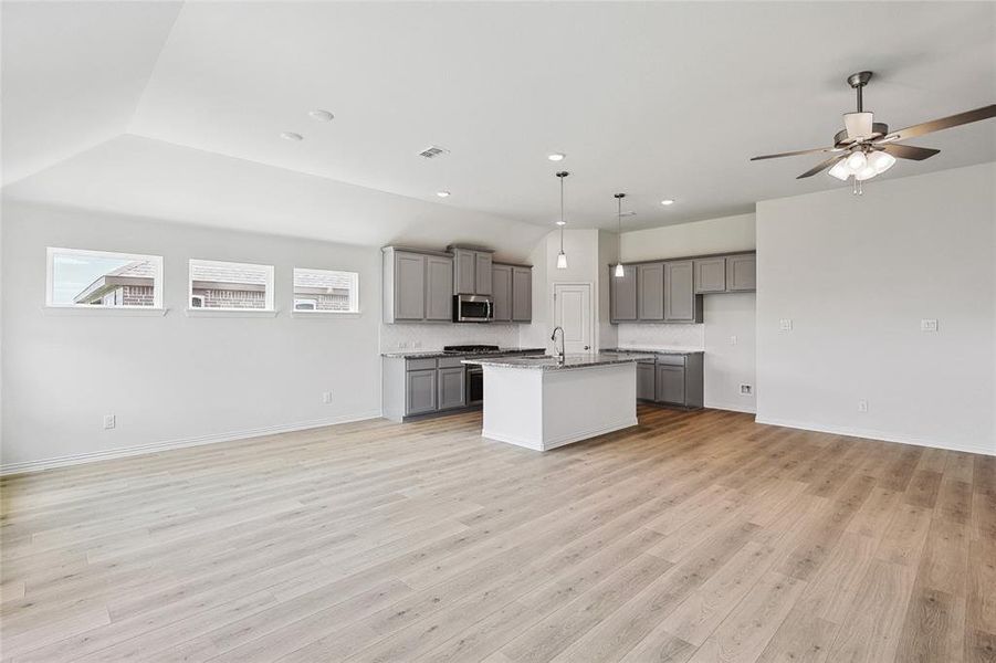 Kitchen with a center island with sink, appliances with stainless steel finishes, light hardwood / wood-style floors, gray cabinets, and ceiling fan