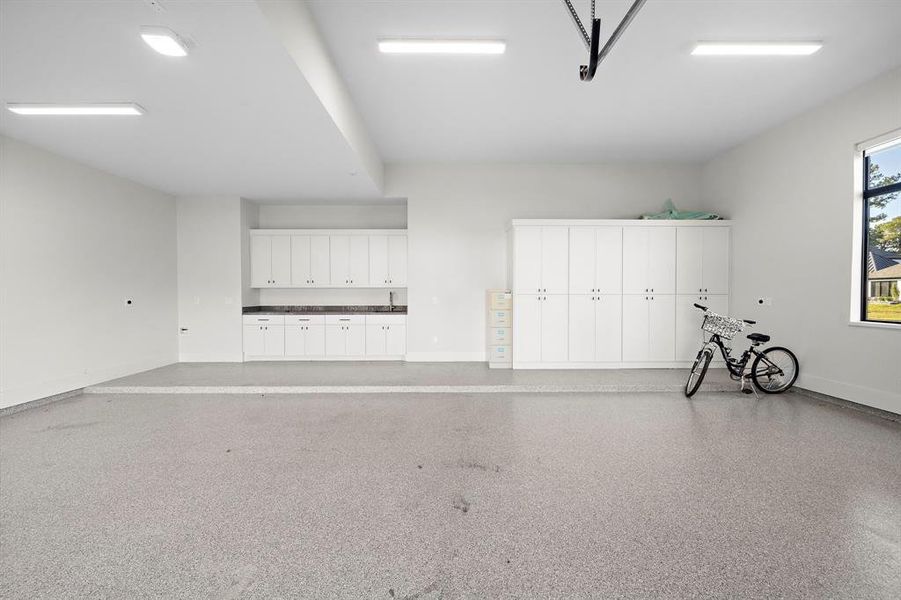 Oversized Garage Doors, Epoxy Flooring, built-in cabinets, workstation with granite countertops, 3 electric car charging outlets, 4x15 storage room.