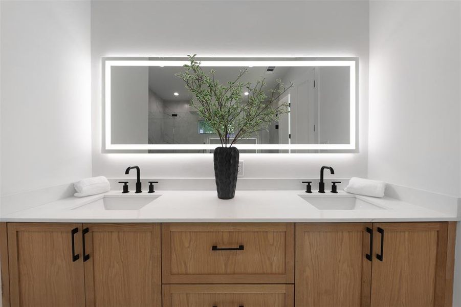 Full bath featuring double vanity and a stall shower