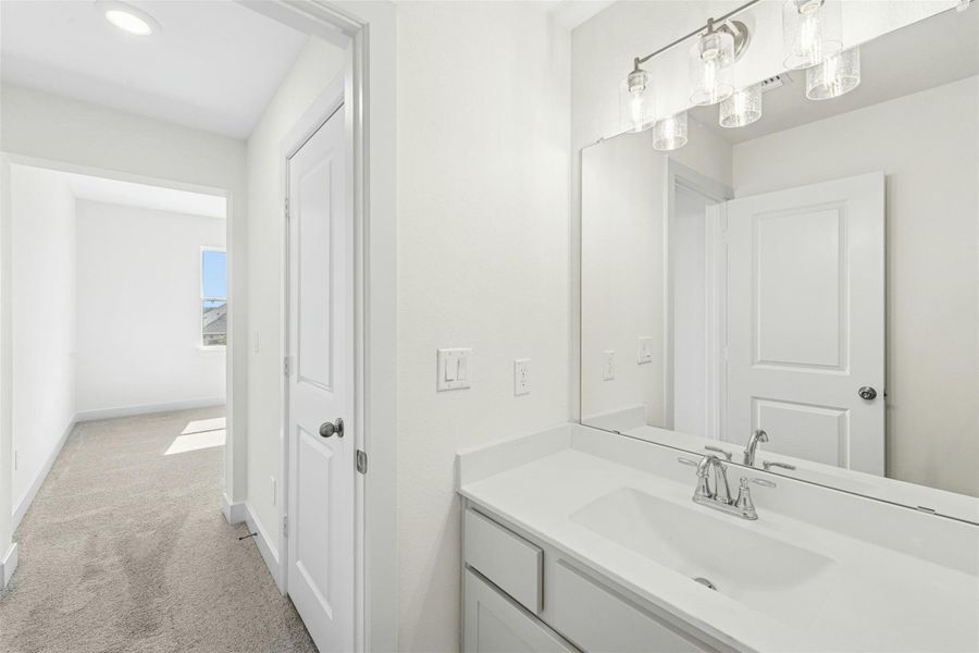Bathroom featuring vanity and light colored carpet