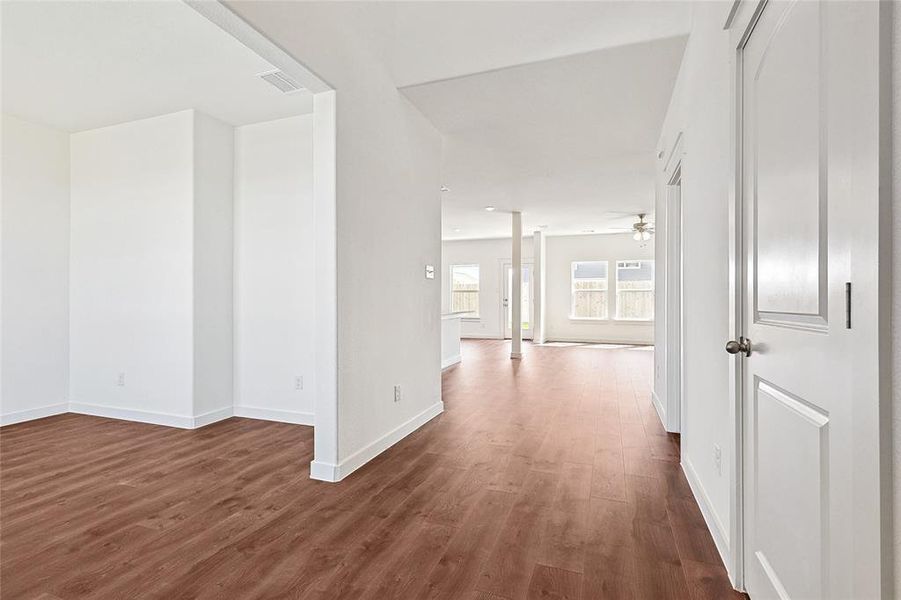 Hallway featuring dark wood-style floors and baseboards