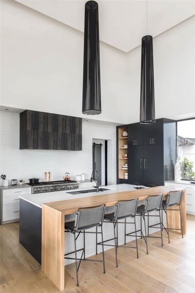 Kitchen with a large island, tasteful backsplash, modern cabinets, and a kitchen bar