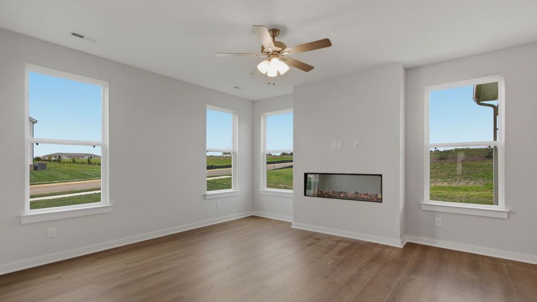 Bright gathering room with multiple windows and fireplace
