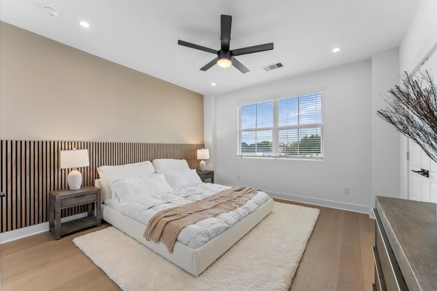 The luxurious primary ensuite features sleek modern finishes, a glass-enclosed shower with stylish tile, and a double-sink vanity topped with quartz countertops, complemented by two contemporary mirrors and lighting fixtures, creating a bright, elegant, and functional retreat.