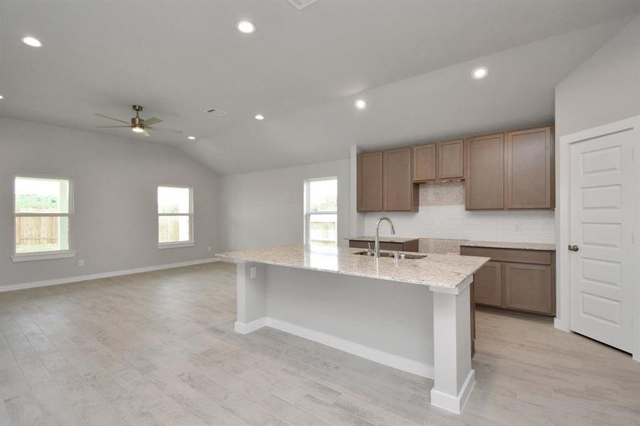 Large island at the center of the kitchen.  Sample photo of completed home with similar floor plan. Actual colors and selections may vary.