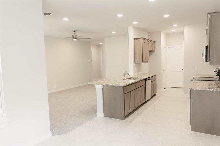 Kitchen featuring stainless steel dishwasher, ceiling fan, sink, stove, and light tile patterned floors