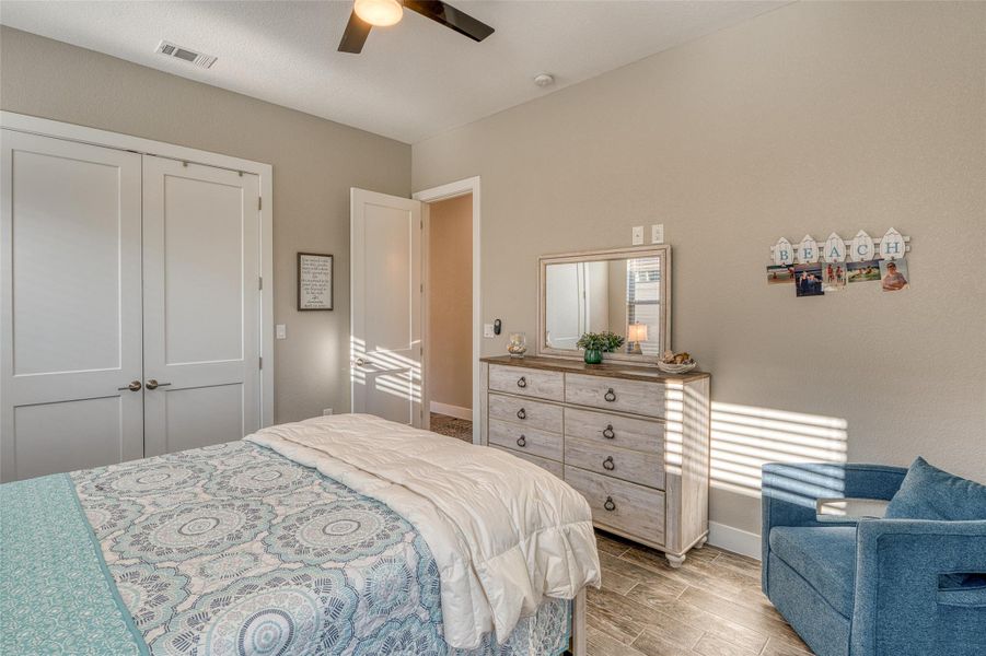 Bedroom with wood tiled floors, a closet, and ceiling fan
