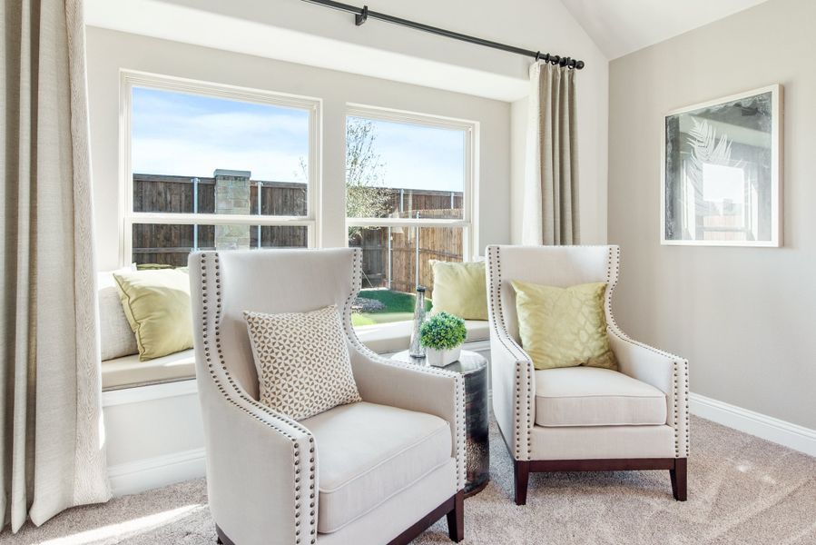Sitting area with two cream armchairs, window bench seat, and large windows overlooking backyard Sitting area with two cream armchairs, window bench seat, and large windows overlooking backyard