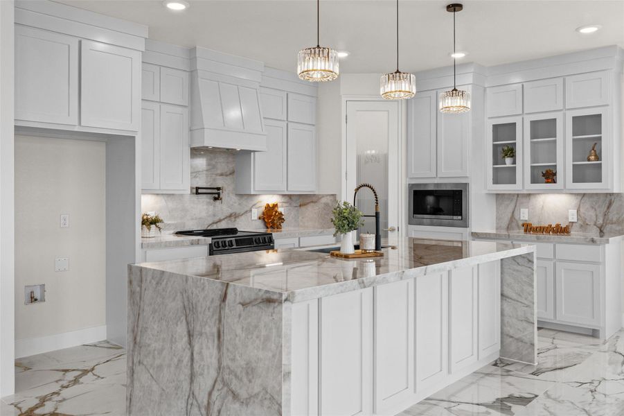 Gleaming marble-veined floors and matching stone countertops elevate this impeccably designed culinary workspace.