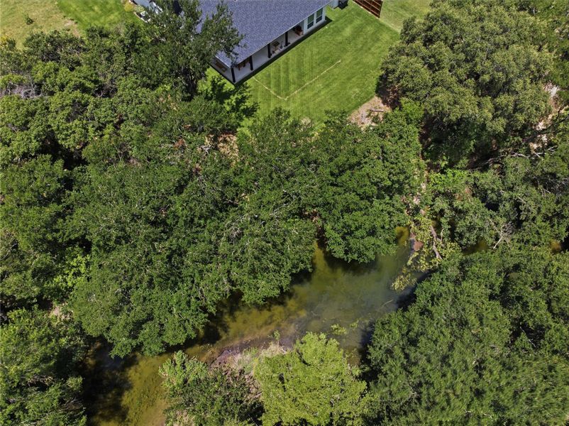 An aerial perspective reveals a serene, wooded lot bordering a tranquil pond, offering a private, natural setting. An aerial perspective reveals a serene, wooded lot bordering a tranquil pond, offering a private, natural setting.