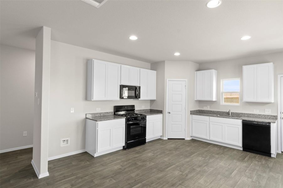 Kitchen with black appliances, recessed lighting, dark wood-style flooring, and white cabinetry Kitchen with black appliances, recessed lighting, dark wood-style flooring, and white cabinetry