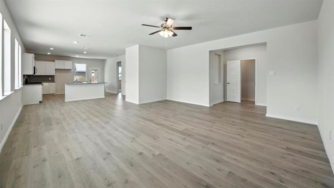 Unfurnished living room featuring light wood-style flooring, a ceiling fan, and recessed lighting