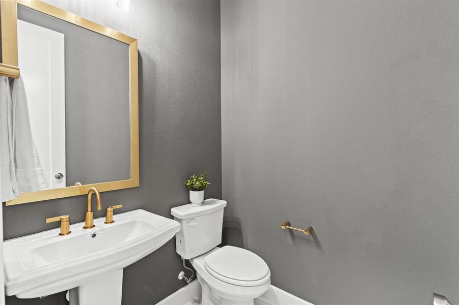 Half bathroom featuring toilet and a textured wall