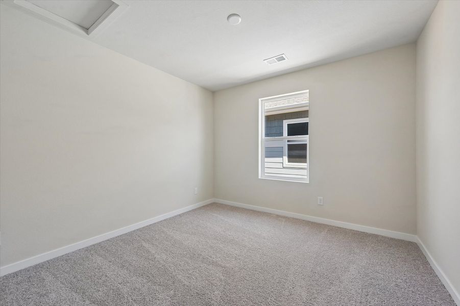 A room with a window and carpet.