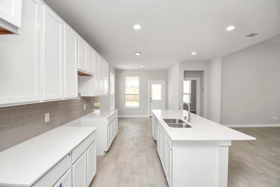 Another view of kitchen with massive island and extended counter space. Sample photo of completed home with similar floor plan. As-built interior colors and selections may vary.