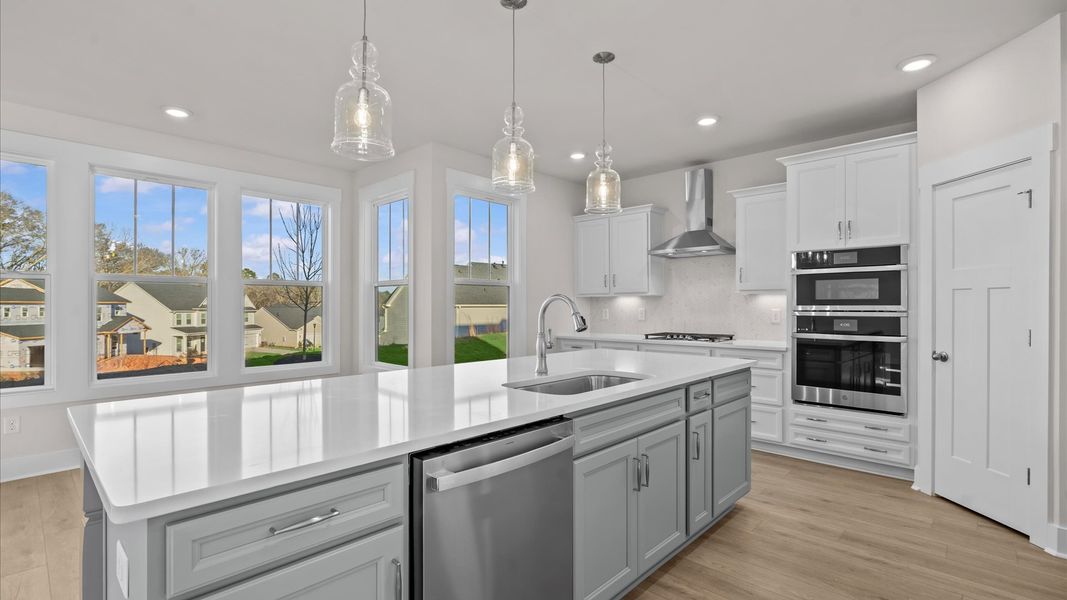 Memorable meals begin in this vibrant kitchen with pendant lighting and a thoughtfully designed island