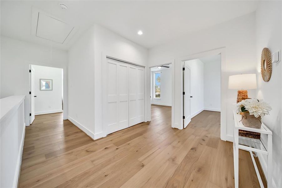 This photo was taken in another staged property with the same finishes and layout. Second floor landing with a view of the laundry space and bedrooms.