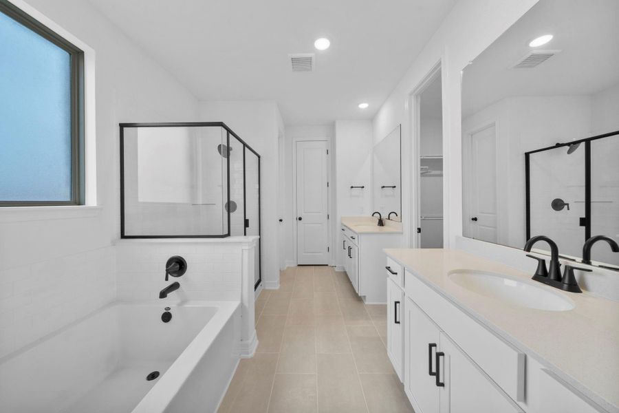 The primary bath featuring the AW Harmony Collection offers a soothing escape with a soaking tub, separate shower, and relaxed farmhouse finishes.