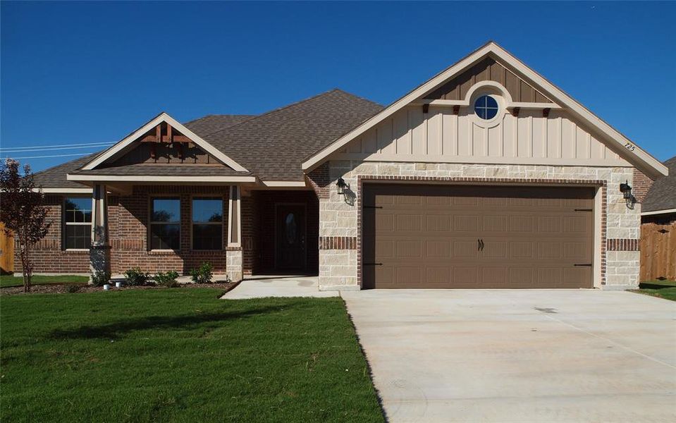 Craftsman inspired home with a garage and a front lawn