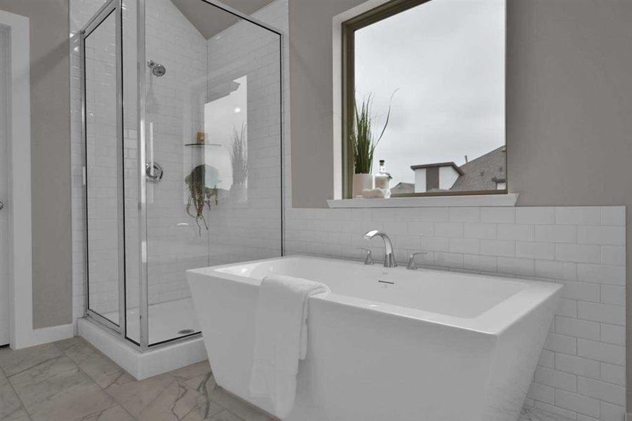 Relaxing tub, frameless glass shower, and modern tile. (Original Builder Staged Photo 2024)