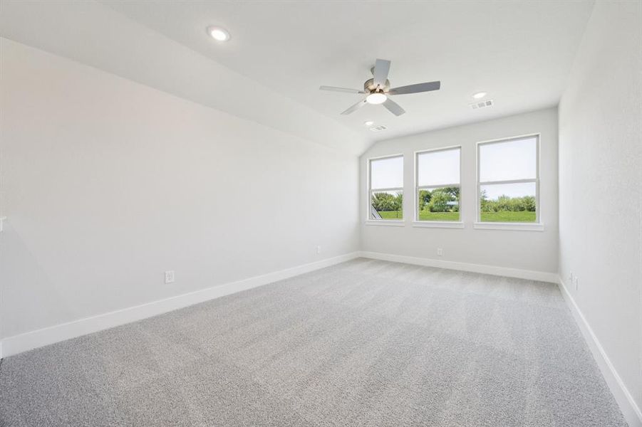 Spare room featuring light carpet, recessed lighting, ceiling fan, and vaulted ceiling