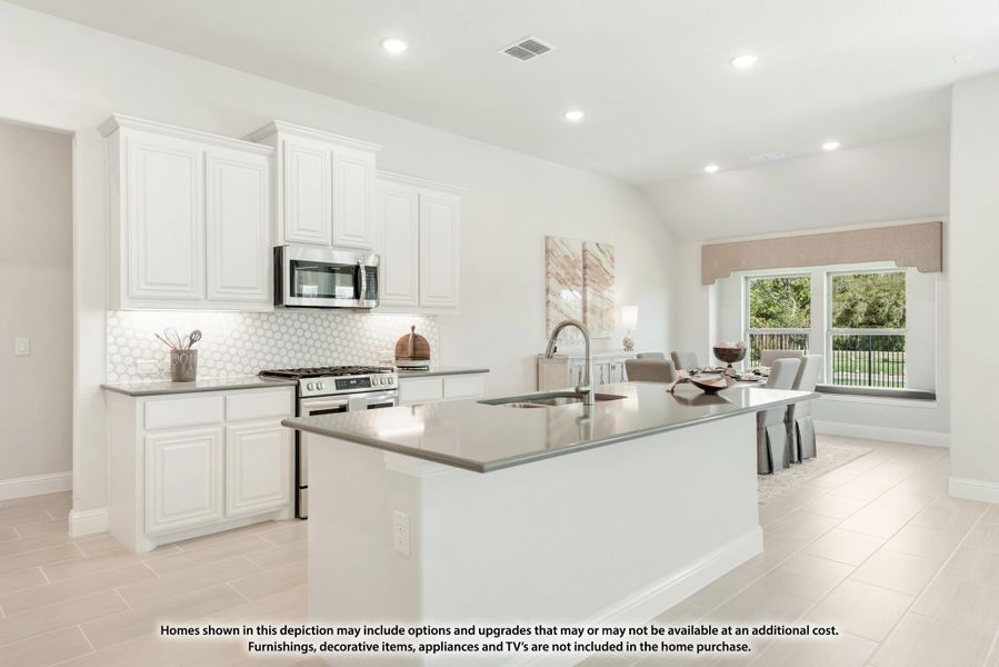 Open kitchen with white cabinets, center island with sink, stainless appliances, and tile floors opening to dining area Open kitchen with white cabinets, center island with sink, stainless appliances, and tile floors opening to dining area