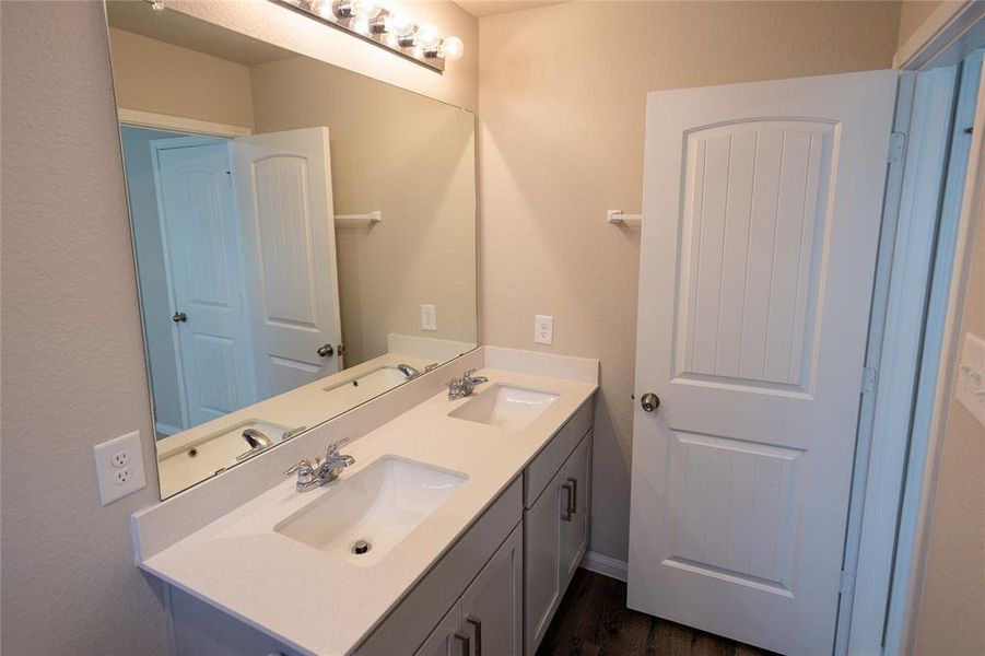 Primary bathroom with double vanity, designer fixtures, and spa-like shower.