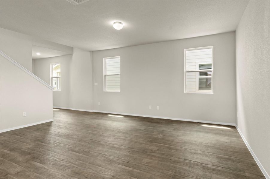 Spare room with dark wood-type flooring and stairway