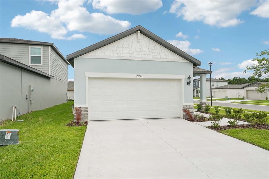 Front exterior of a new home in The Grove at Stuart Crossing - Premier Series, Bartow, FL, highlighting curb appeal (Image 16). Front exterior of a new home in The Grove at Stuart Crossing - Premier Series, Bartow, FL, highlighting curb appeal (Image 16).