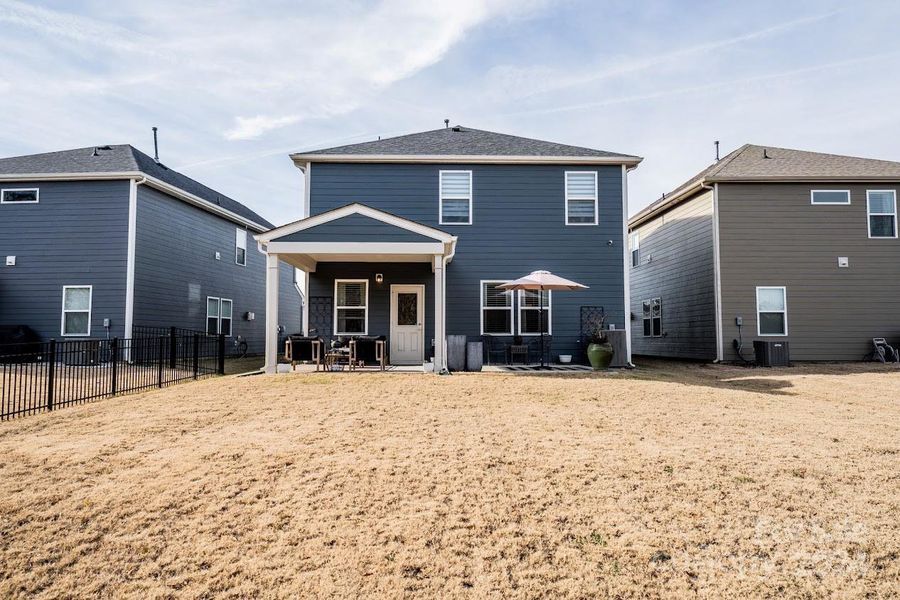 A covered patio and an amazing backyard that backs to a treeline for privacy.